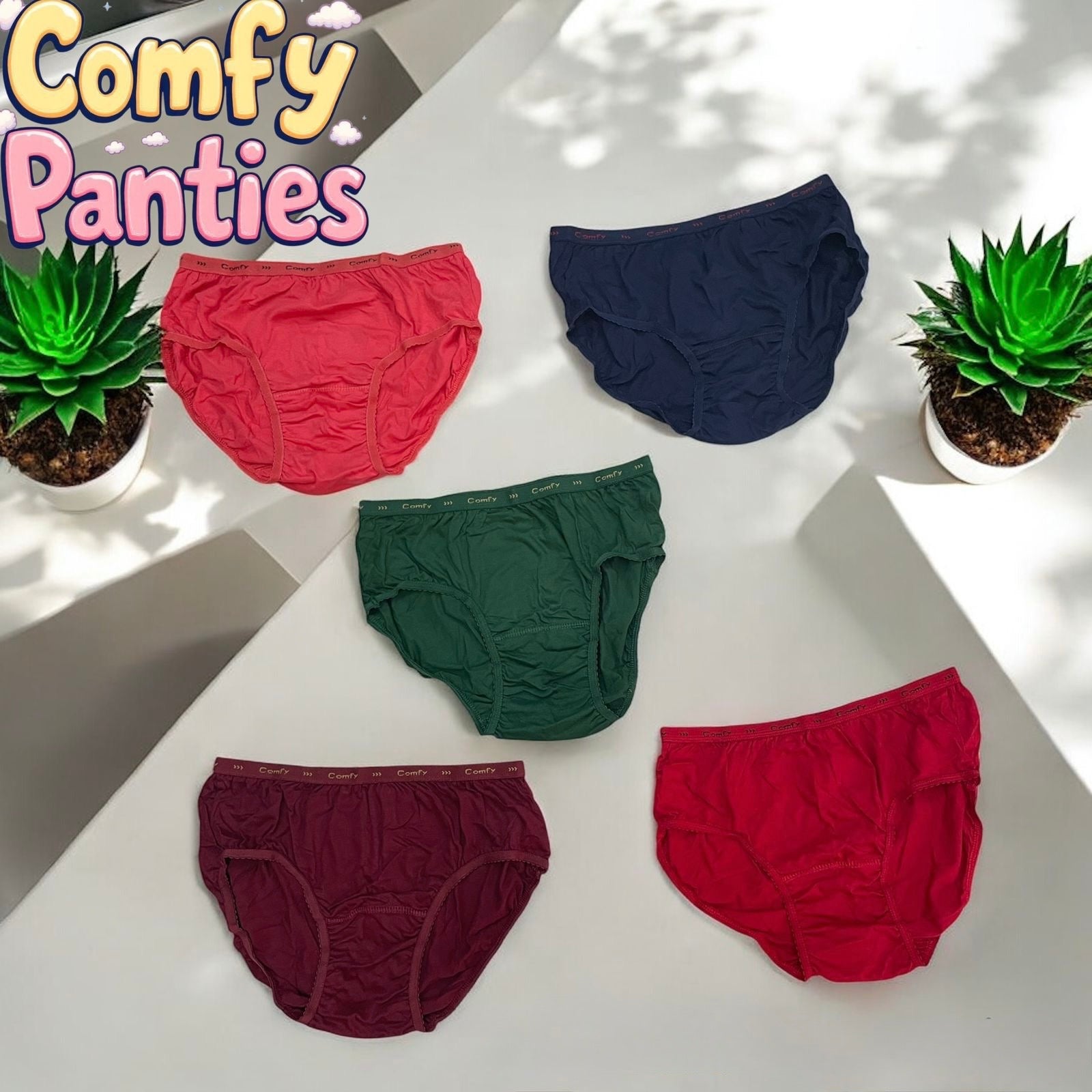 Five pairs of colorful panties on a white surface with 'Comfy Panties' branding and two potted plants.